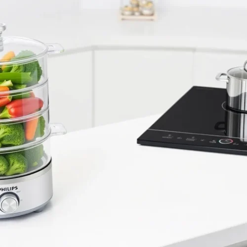 Parownica z warzywami i nowoczesna kuchenka elektryczna, co ilustruje, jak używać tych urządzeń.